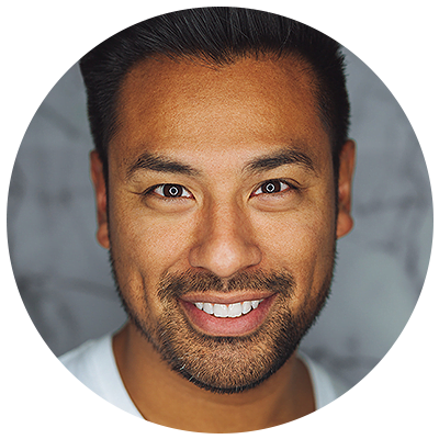 Smiling Asian man with dark hair and beard, looking directly at the camera.